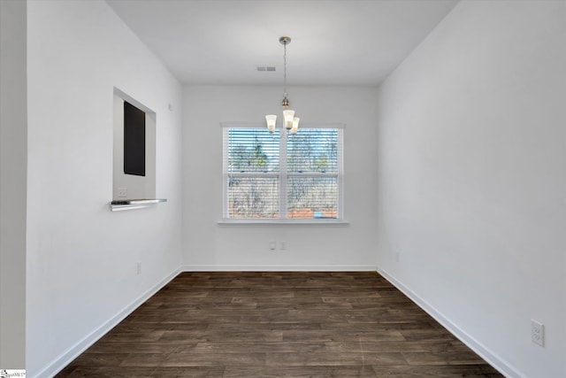 unfurnished dining area featuring dark hardwood / wood-style flooring and a chandelier