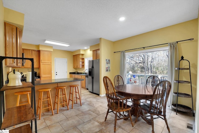 dining space featuring a textured ceiling and sink