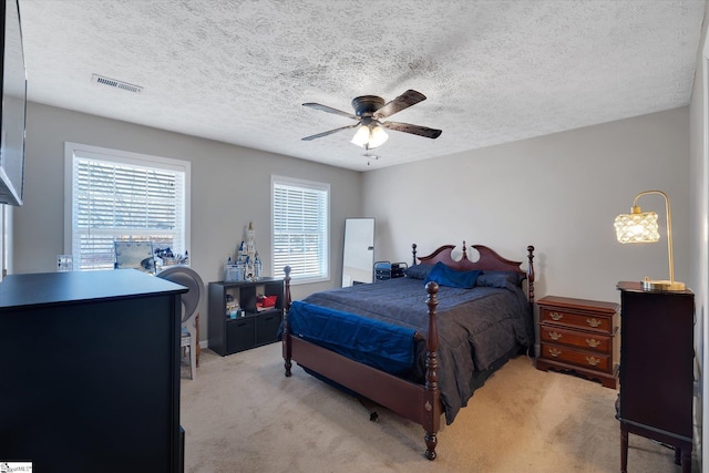 carpeted bedroom with a textured ceiling and ceiling fan