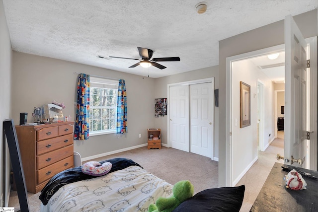 carpeted bedroom with ceiling fan, a textured ceiling, and a closet