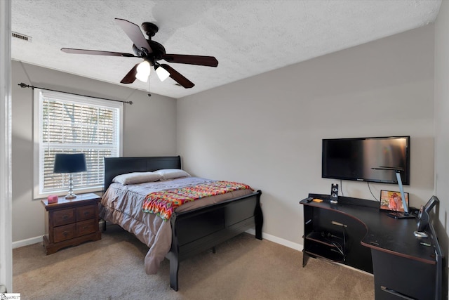 carpeted bedroom featuring ceiling fan and a textured ceiling