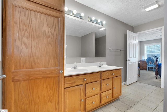 bathroom with tile patterned flooring, vanity, and a textured ceiling