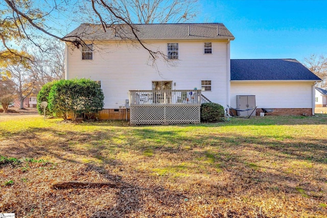 rear view of house with a wooden deck and a yard