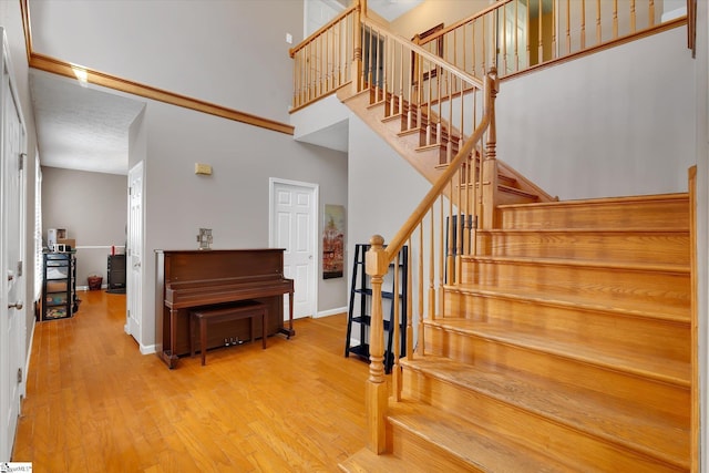 stairs featuring hardwood / wood-style floors and a towering ceiling