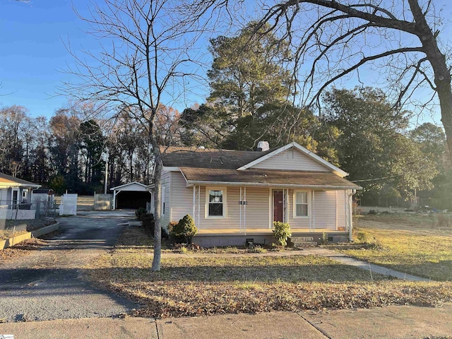 bungalow-style house featuring a garage and an outbuilding