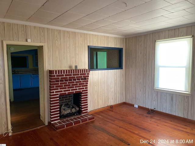 unfurnished living room with a fireplace, ornamental molding, and dark wood-type flooring