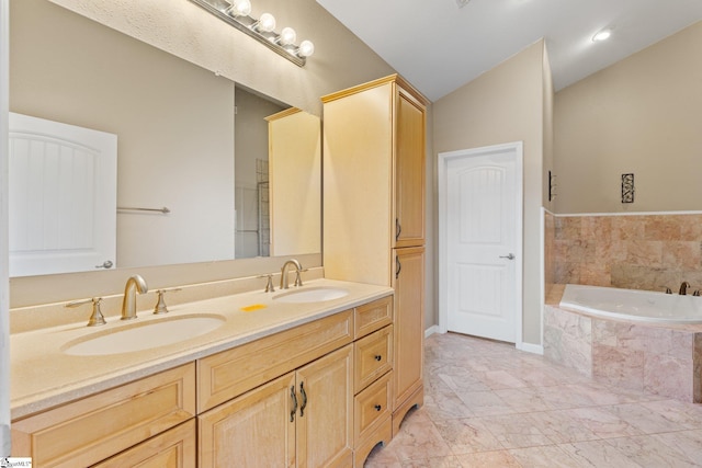 bathroom with vanity, a relaxing tiled tub, and lofted ceiling