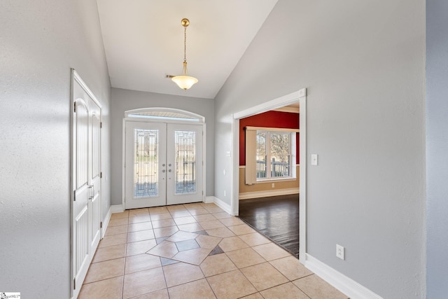 entrance foyer featuring vaulted ceiling, light tile patterned floors, and french doors