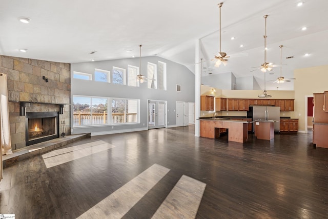 unfurnished living room with a fireplace, dark hardwood / wood-style flooring, high vaulted ceiling, and ceiling fan