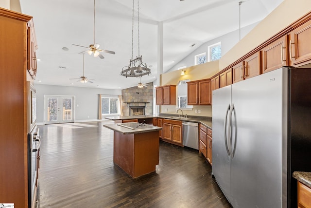 kitchen featuring ceiling fan, sink, dark wood-type flooring, stainless steel appliances, and a kitchen island