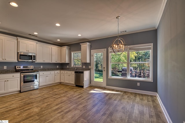 kitchen featuring a chandelier, appliances with stainless steel finishes, white cabinetry, and hardwood / wood-style floors