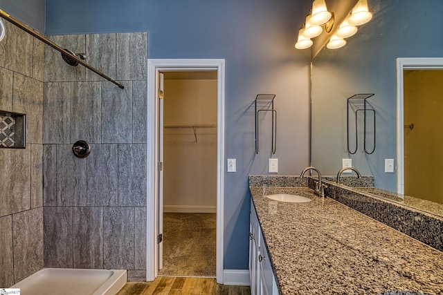 bathroom featuring tiled shower, vanity, and hardwood / wood-style flooring