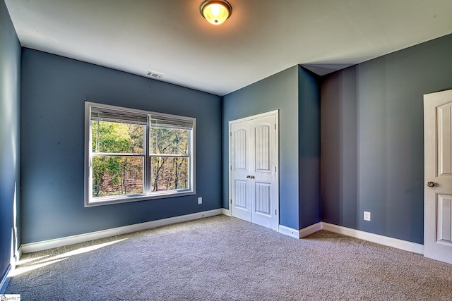 unfurnished bedroom featuring light carpet and a closet