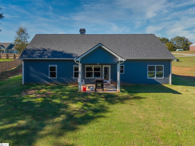 rear view of property with a patio and a lawn