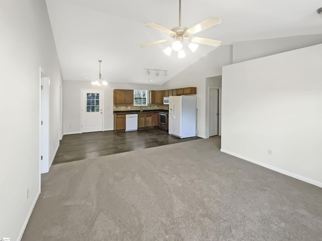 unfurnished living room featuring ceiling fan with notable chandelier, dark carpet, and lofted ceiling