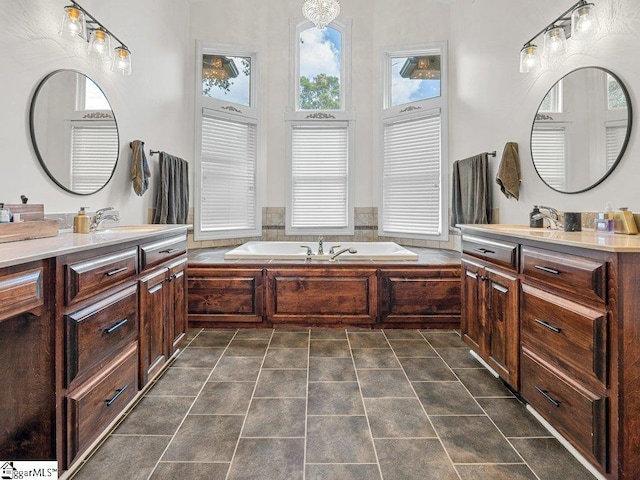 bathroom featuring tile patterned flooring, vanity, and a bath