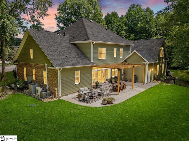 back house at dusk featuring a yard, an outdoor hangout area, a patio area, and central air condition unit