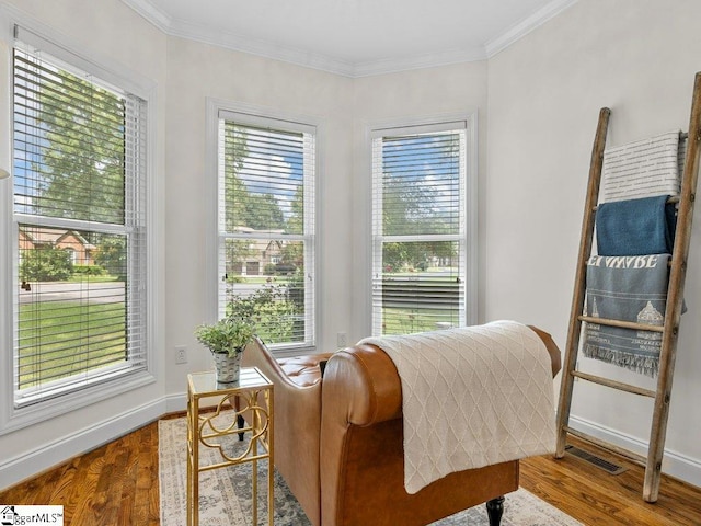 living area with ornamental molding and light hardwood / wood-style flooring