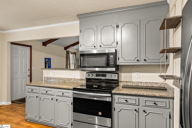 kitchen with appliances with stainless steel finishes, gray cabinetry, a textured ceiling, beamed ceiling, and light hardwood / wood-style floors