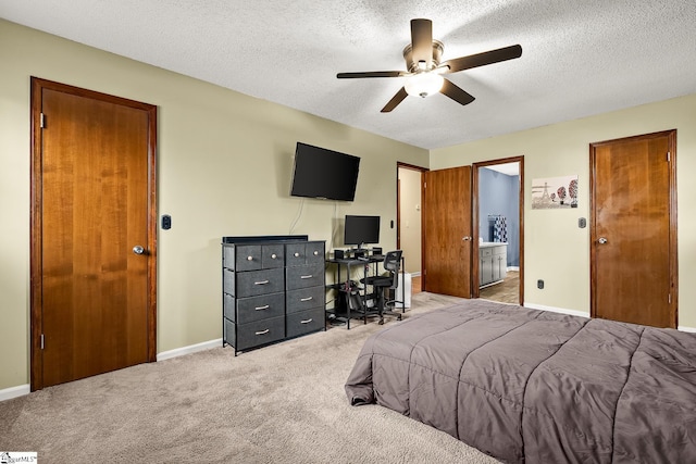 bedroom with connected bathroom, ceiling fan, carpet, and a textured ceiling