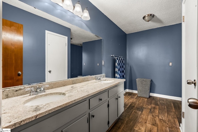 bathroom with vanity, a textured ceiling, and hardwood / wood-style flooring