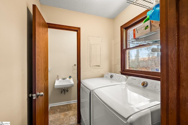 laundry room featuring a textured ceiling, sink, and washing machine and clothes dryer