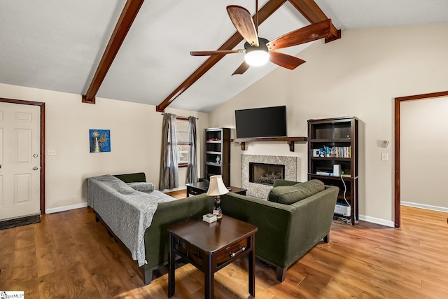 living room featuring wood-type flooring, lofted ceiling with beams, and ceiling fan