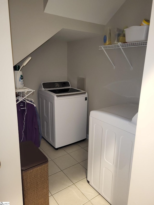 laundry area with washer and clothes dryer and light tile patterned flooring