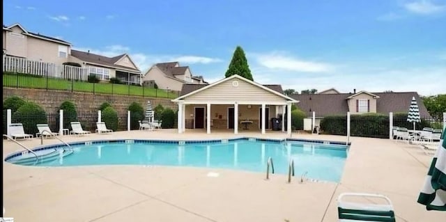 view of swimming pool with an outbuilding and a patio