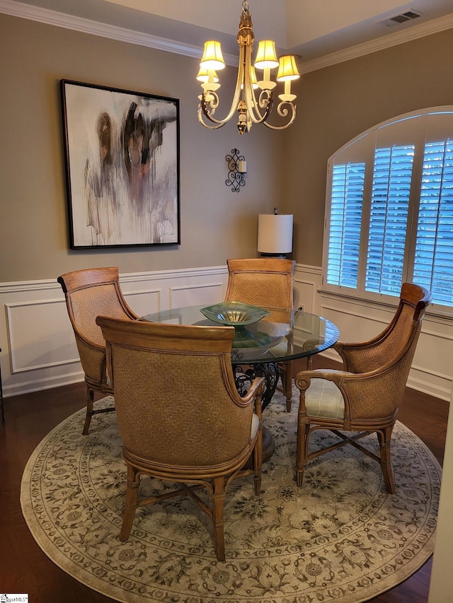 dining area with ornamental molding, dark hardwood / wood-style floors, and a notable chandelier