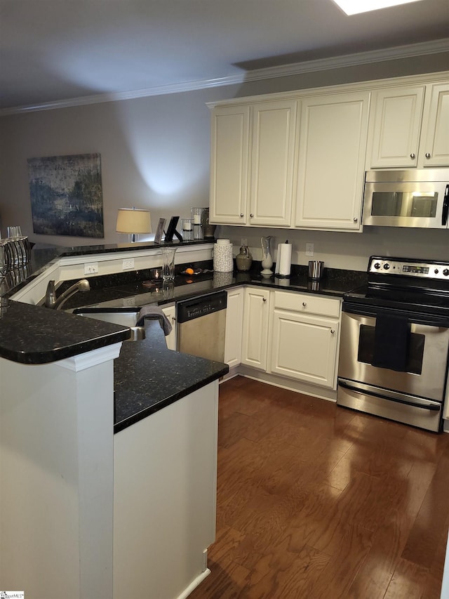 kitchen featuring kitchen peninsula, white cabinetry, ornamental molding, and appliances with stainless steel finishes