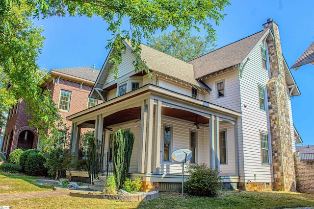 view of front facade with ceiling fan, covered porch, and a front yard