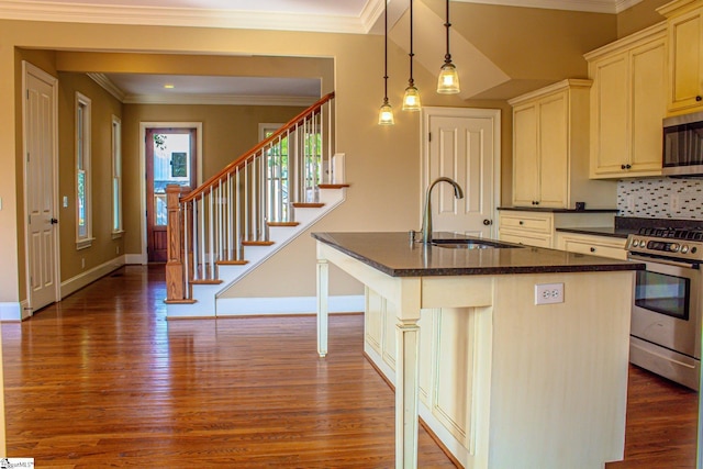 kitchen featuring a kitchen bar, sink, an island with sink, and stainless steel appliances