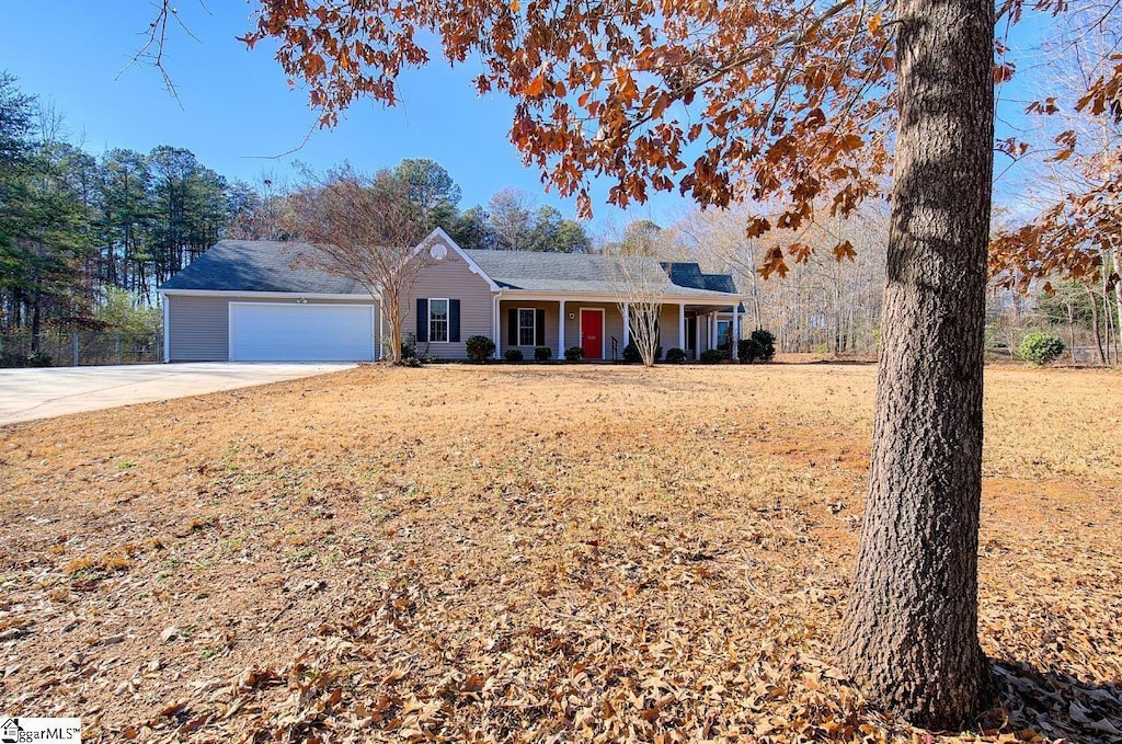 single story home with covered porch, a front yard, and a garage