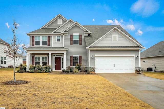 craftsman-style home with central AC unit, a front yard, and a garage