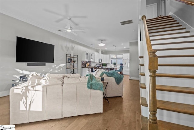 living room featuring ceiling fan, hardwood / wood-style floors, and ornamental molding