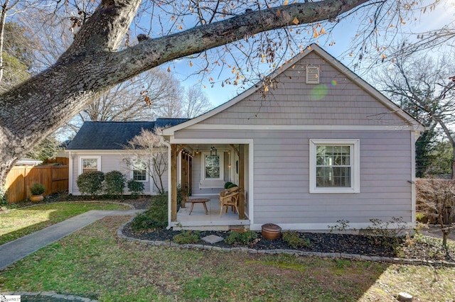 view of front of house featuring covered porch and a front lawn