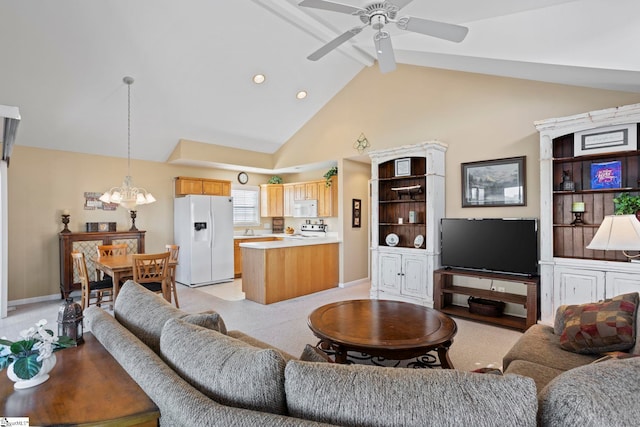 living room with beam ceiling, high vaulted ceiling, light colored carpet, and ceiling fan with notable chandelier