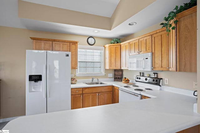 kitchen with kitchen peninsula, white appliances, and sink