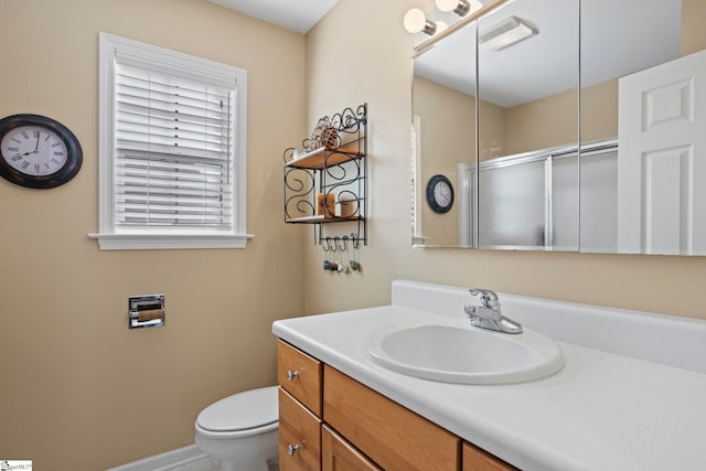 bathroom featuring vanity, toilet, and an enclosed shower