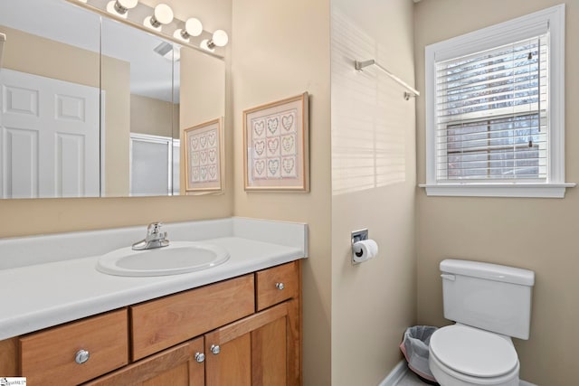 bathroom featuring walk in shower, vanity, and toilet