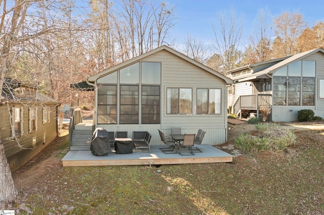 rear view of house with a deck and a sunroom