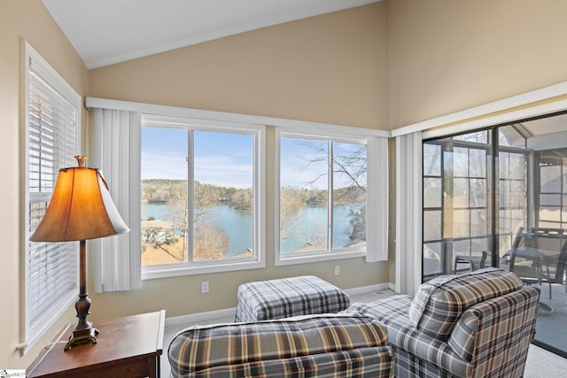 interior space with a water view, vaulted ceiling, and a healthy amount of sunlight