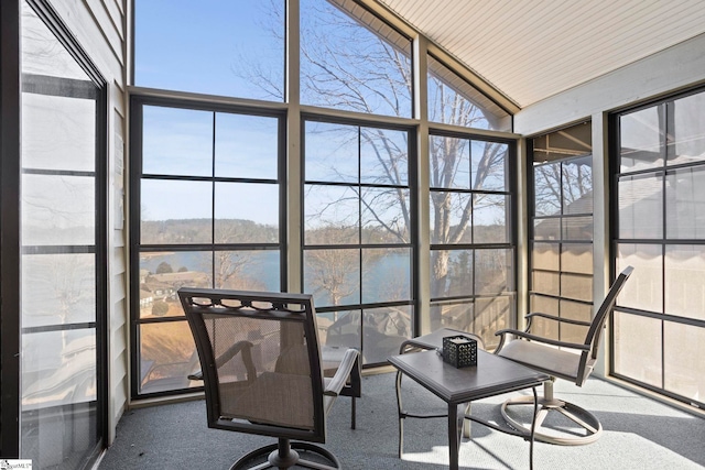 sunroom featuring a water view and vaulted ceiling