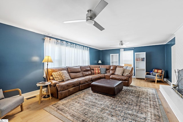 living room with crown molding, ceiling fan, and wood-type flooring