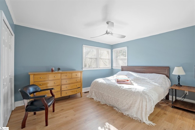 bedroom with ceiling fan, light hardwood / wood-style floors, ornamental molding, and a closet