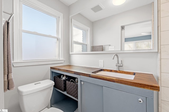 bathroom featuring vanity, toilet, and plenty of natural light