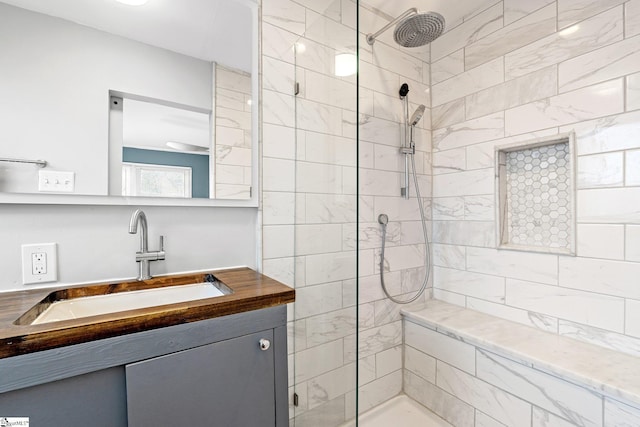 bathroom featuring a tile shower and vanity