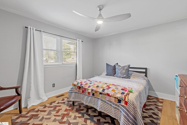 bedroom featuring light hardwood / wood-style flooring, ceiling fan, and crown molding