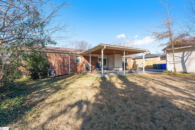 rear view of property with a lawn and a patio